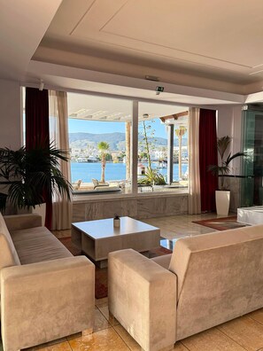 A spacious living area with a view of the sea and mountains, furnished with sofas and a coffee table. - Kosta Palace (Kos)