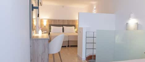 Una habitación de hotel moderna con una cama, un escritorio, una silla y una mesita.