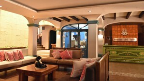 Un vestíbulo con un sofá, una mesa de madera y un letrero que dice "Mansion del Valle".