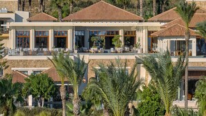 Ein Resort mit mehreren Villen, jede mit einer Terrasse, Sitzgelegenheiten im Freien und Blick auf die umliegende Landschaft.