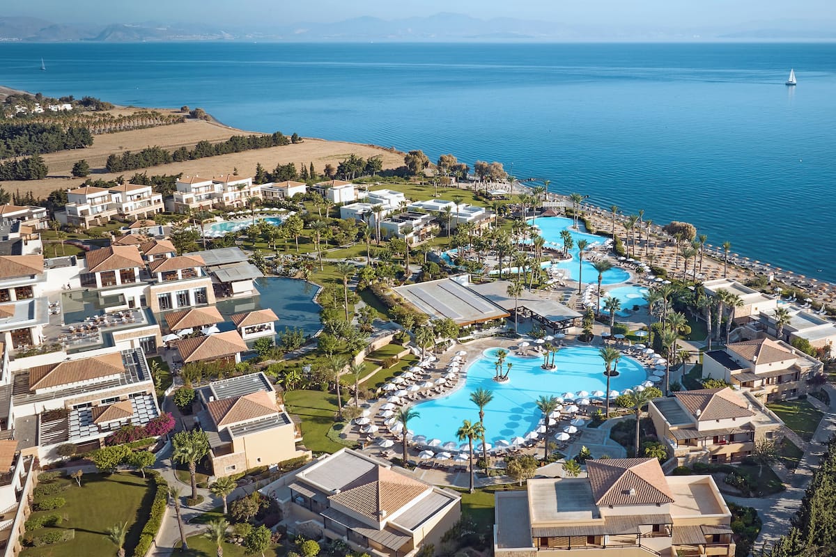 Een resort met meerdere zwembaden, villa's aan het strand en uitzicht op zee.