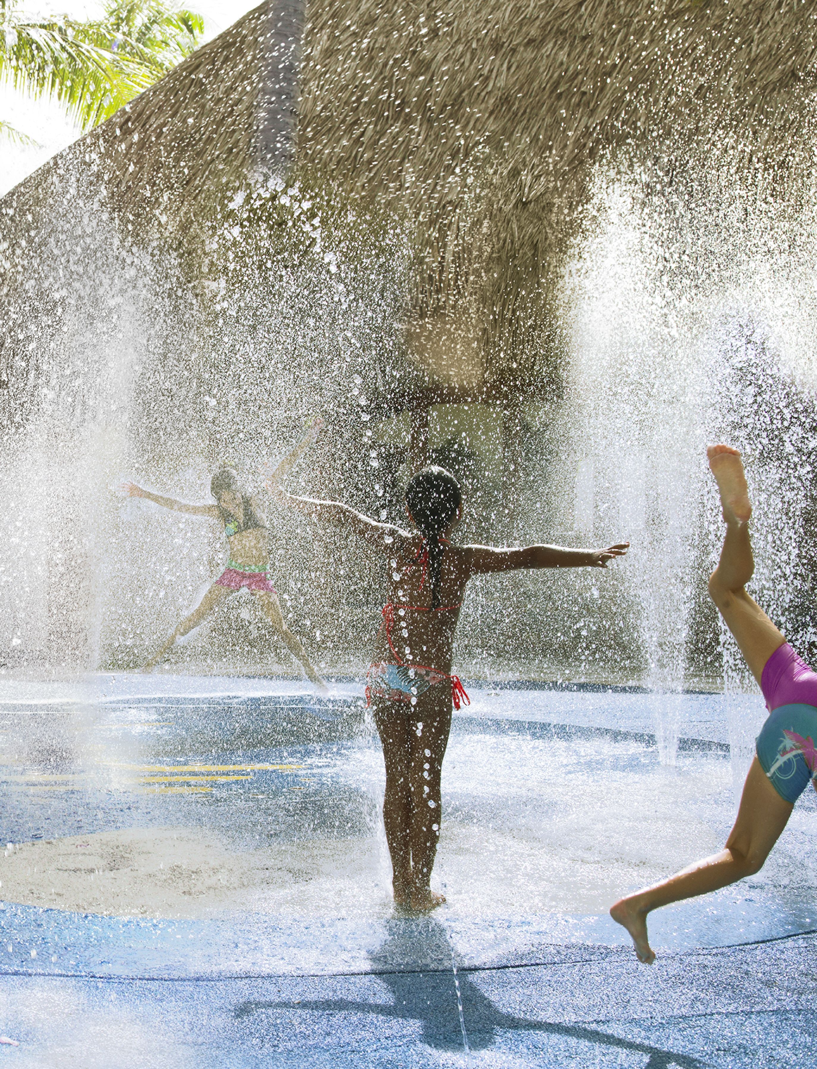 A water play area with a thatched roof structure.