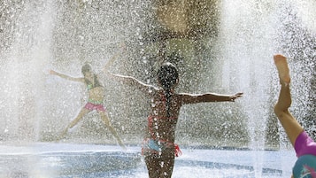 A water play area with a thatched roof structure.