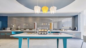 A modern kitchen with a central island, pendant lights, and a patterned backsplash. - One Acapulco Costera (Acapulco)