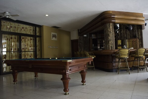 A pool table in a room with a bar area and chairs. - Hotel Camino Real Tikal (San Jose Peten)