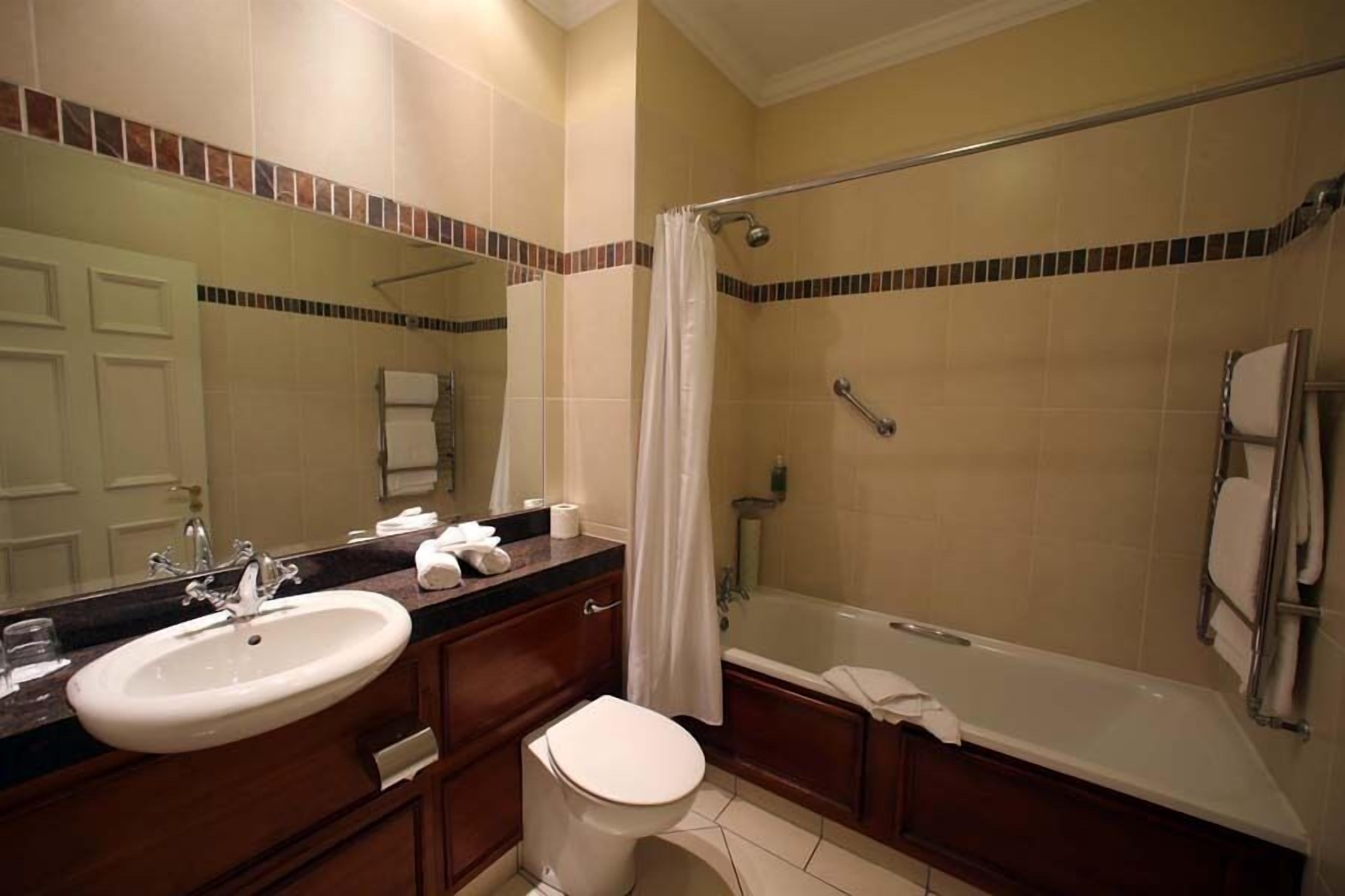 A bathroom with a sink, toilet, and bathtub.