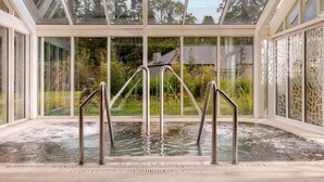 A glass-enclosed hot tub area with metal railings and a view of the surrounding greenery. - Lough Eske Castle (Donegal)