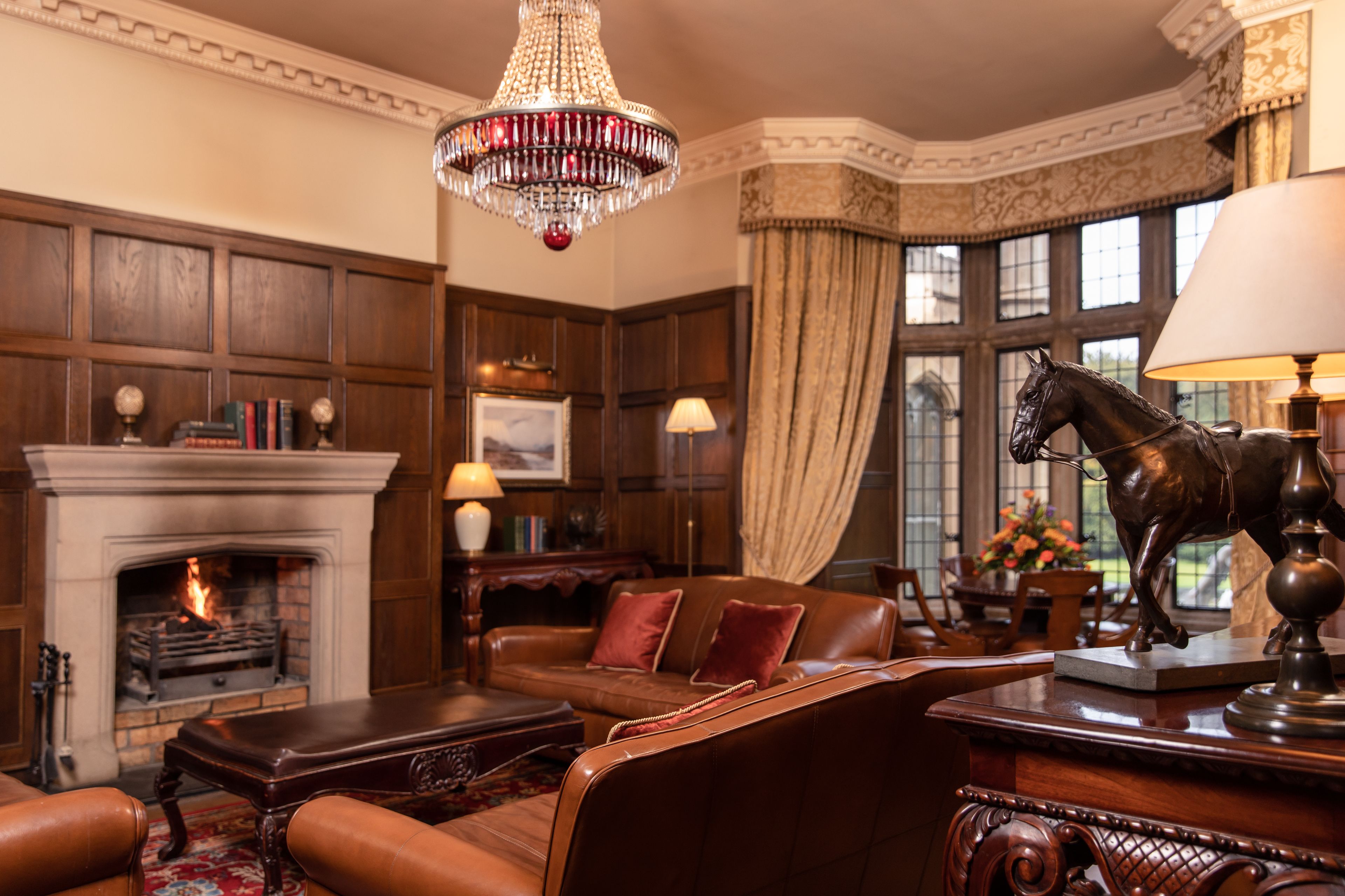 A traditional room with a fireplace, leather furniture, and a decorative horse statue.