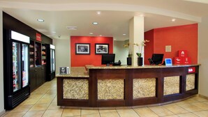 A reception area with a counter, a refrigerator, and a wall with framed pictures.