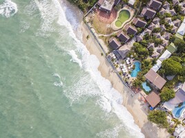 Na praia, espreguiçadeiras, guarda-sóis, toalhas de praia 