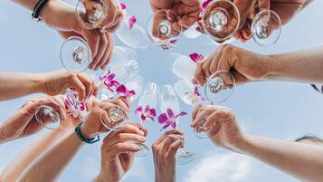 A group of people holding wine glasses in a circle.