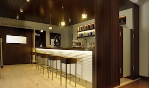 A bar area with a counter, bar stools, and a coffee machine. - Hotel Corona de Galicia (Valga)