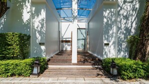 A modern building with a central corridor, wooden steps, and a glass ceiling.