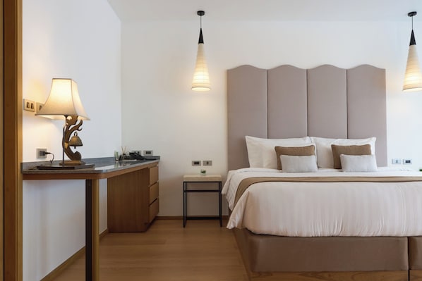 A modern bedroom with a large bed, bedside tables, and pendant lighting. - Malisa Villa Suites (Karon)