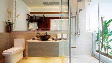 A modern bathroom with a glass-enclosed shower, a large mirror, a vessel sink, and a toilet.