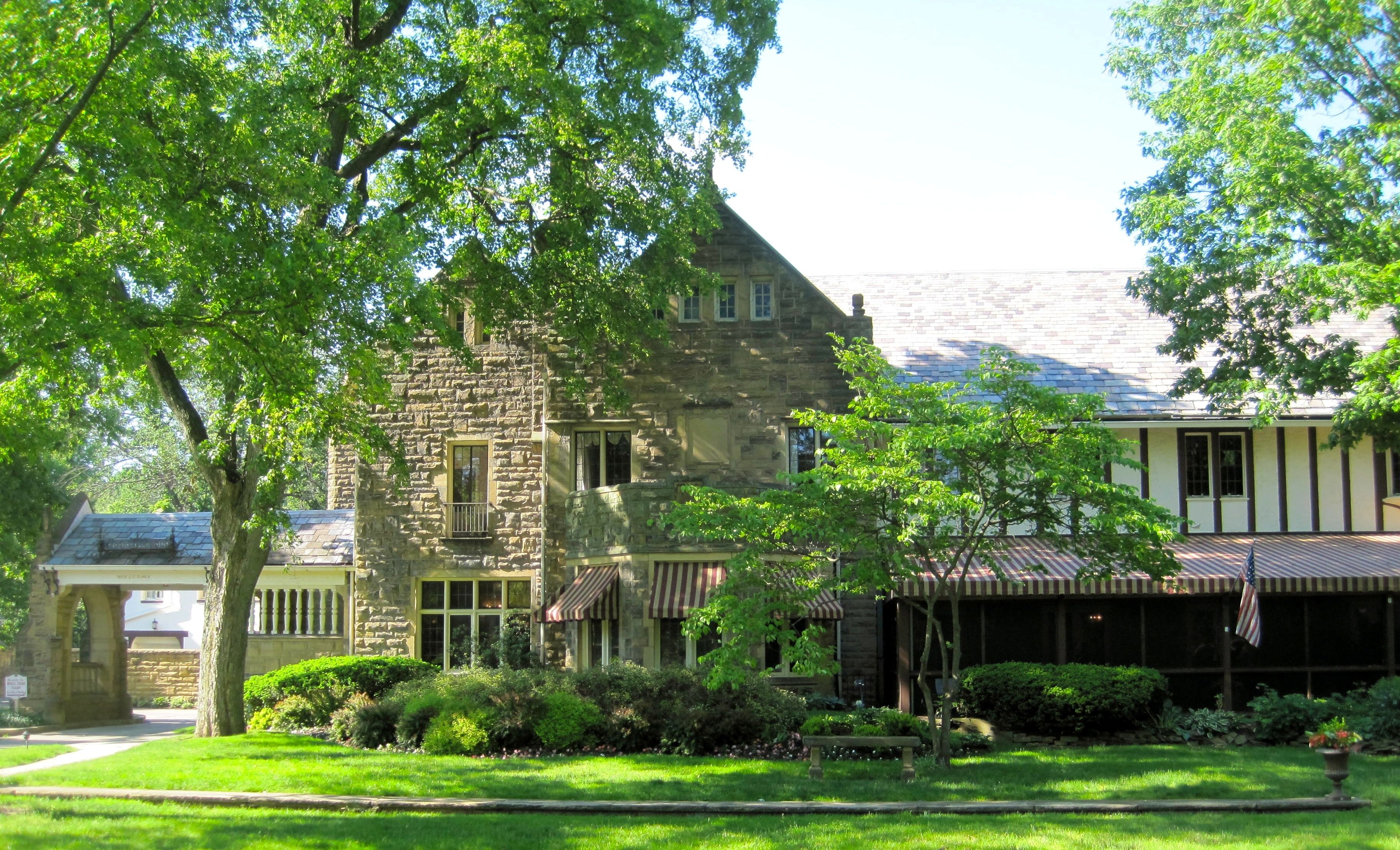 A stone building with a gabled roof and a covered porch.