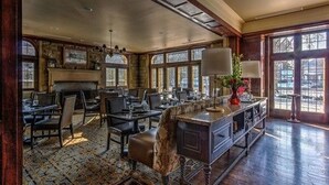 A spacious dining area with high ceilings, large windows, and a fireplace. - Granville Inn (Granville)