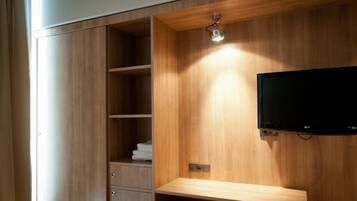 A wooden cabinet with shelves and a television mounted on the wall.