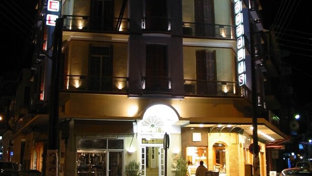 A multi-story hotel with a prominent 'HOTEL' sign, a ground-level entrance, and a visible restaurant or cafe. - Metropolis (Serres)