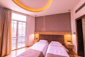 A hotel room with two beds, a large window with a view, and a modern ceiling design. - Metropolis (Serres)