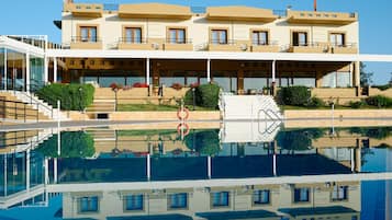 Una piscina al aire libre, una piscina infinita, sombrillas