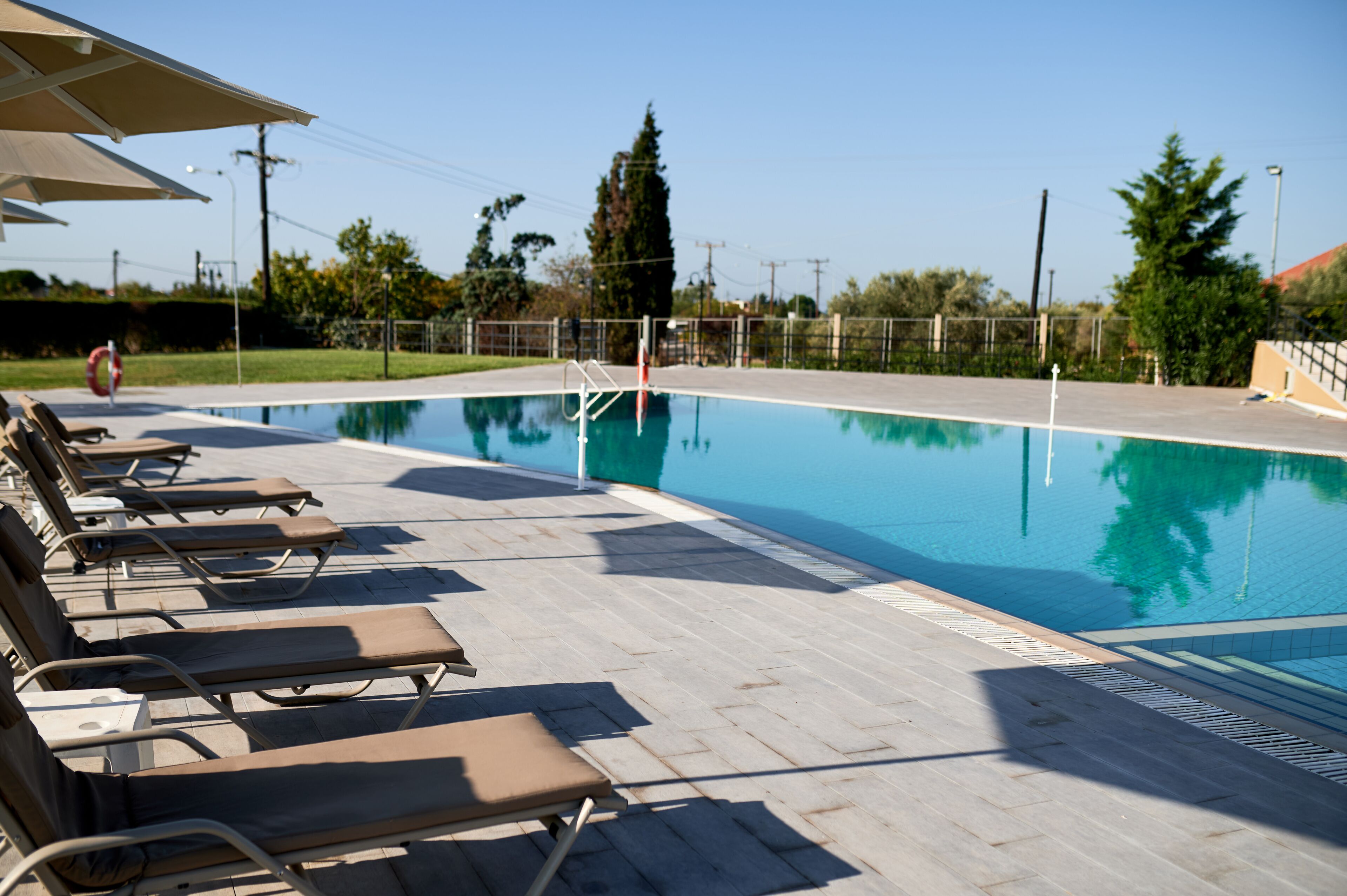 A swimming pool with lounge chairs and a lifebuoy.
