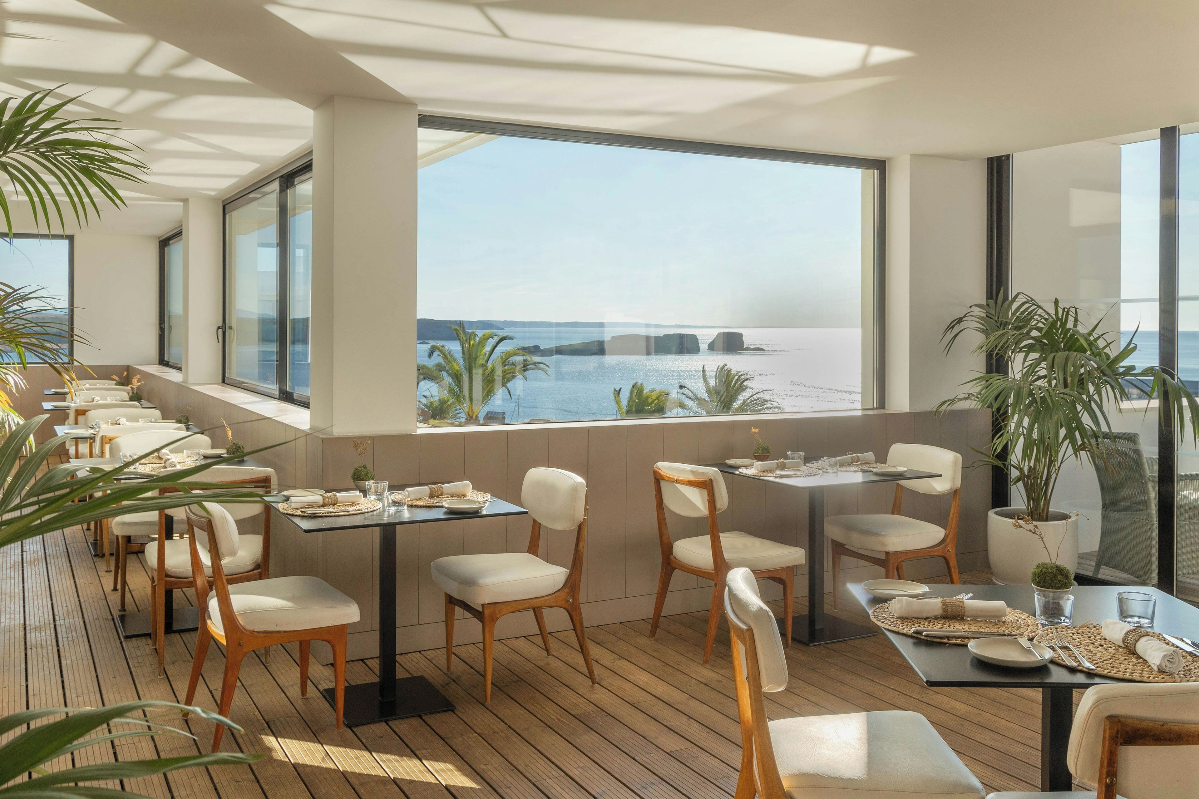 A restaurant with outdoor seating overlooking a body of water.