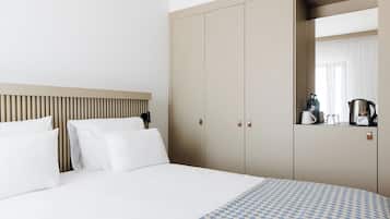 A hotel room with a bed, a wardrobe, and a mirror.