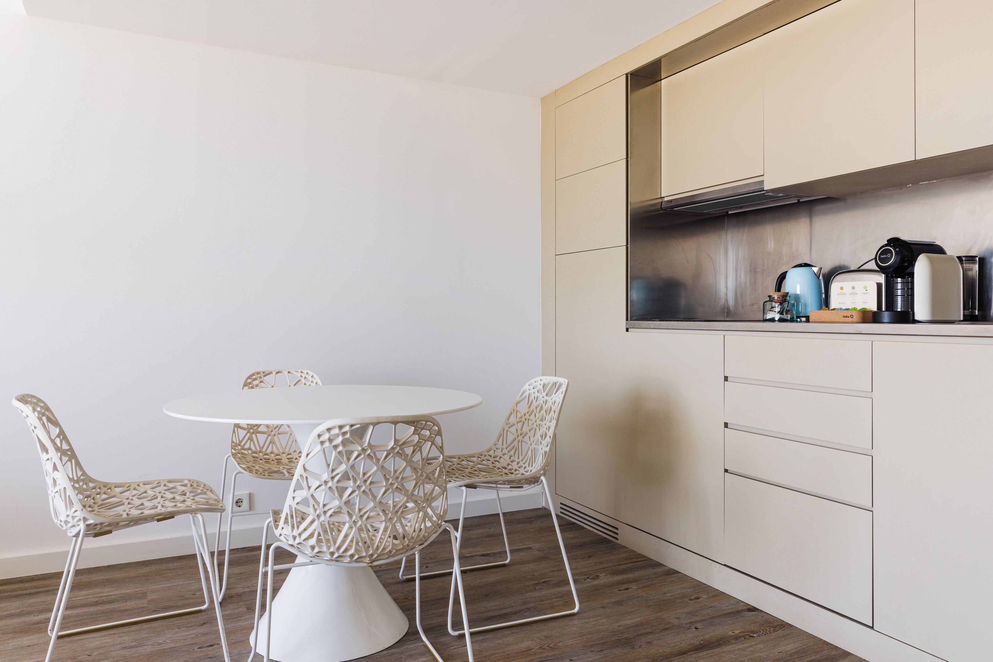 Una cocina moderna con una mesa redonda y cuatro sillas de mimbre.