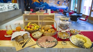 Montaje de bufé con diversos alimentos y un mural de fondo.
