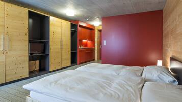 Une chambre à coucher avec un lit, une armoire en bois et un mur rouge.