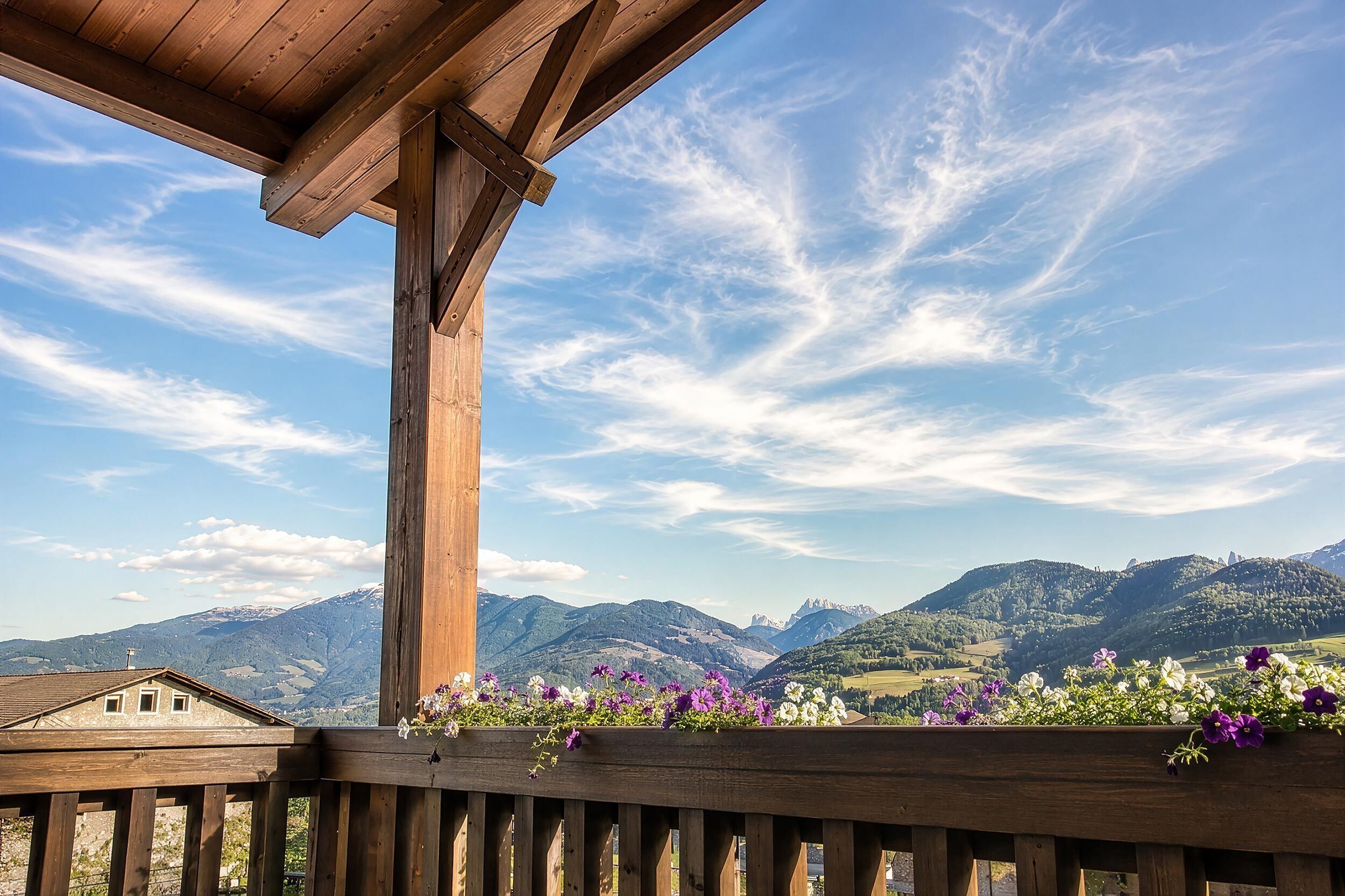 Ein hölzerner Balkon mit Blick auf Berge und einen klaren Himmel.