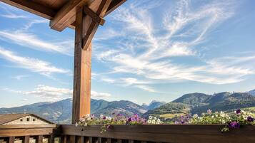 Ein hölzerner Balkon mit Blick auf Berge und einen klaren Himmel.