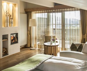 Suíte premium, várias camas | Área de estar | TV