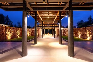 A covered outdoor area with a brick wall, columns, and a pathway leading to a building. - OUTRIGGER Khao Lak Beach Resort (Takua Pa)