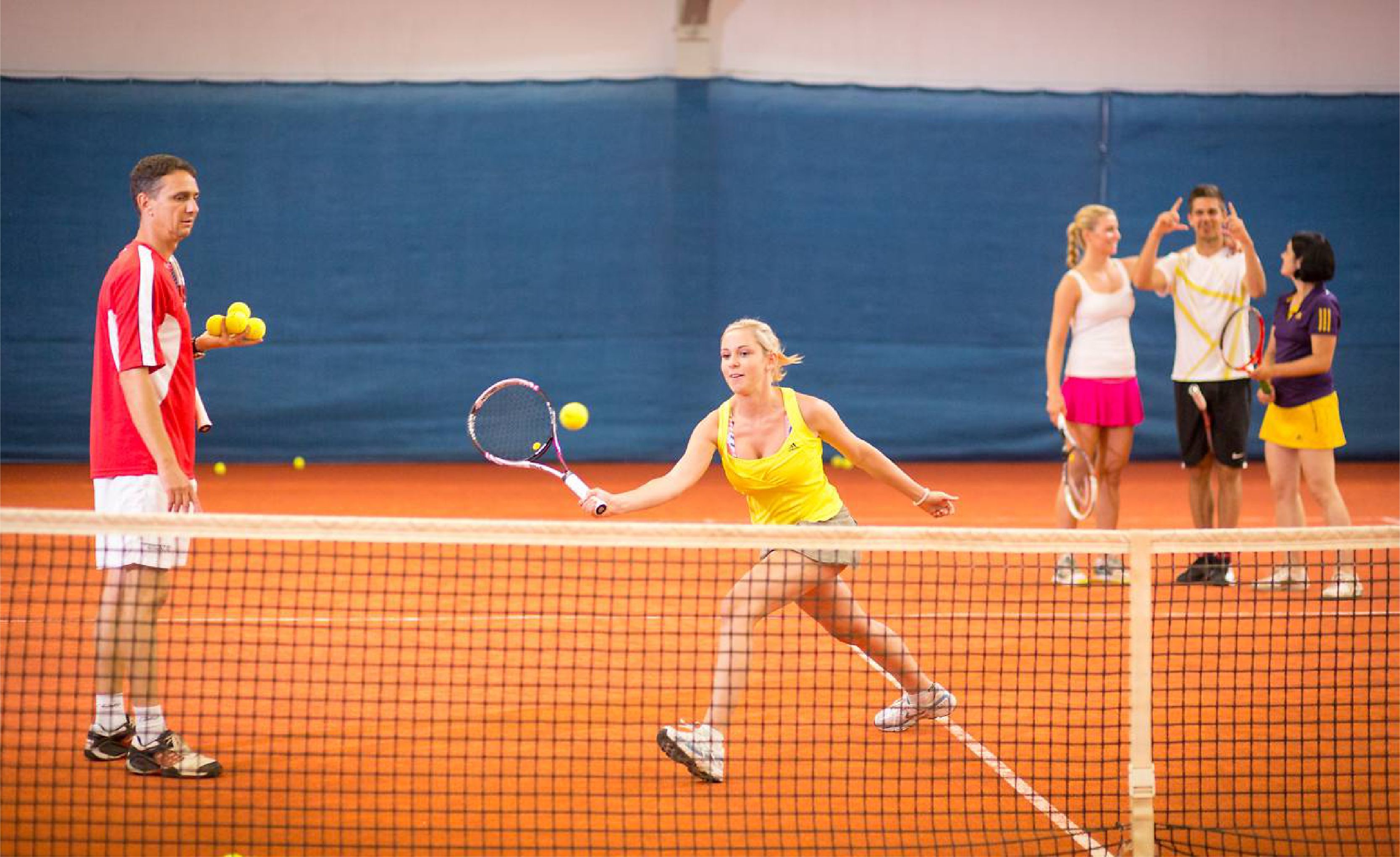 Ein Tennisplatz mit spielenden Personen.