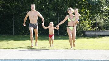 Una familia caminando junto a una piscina.