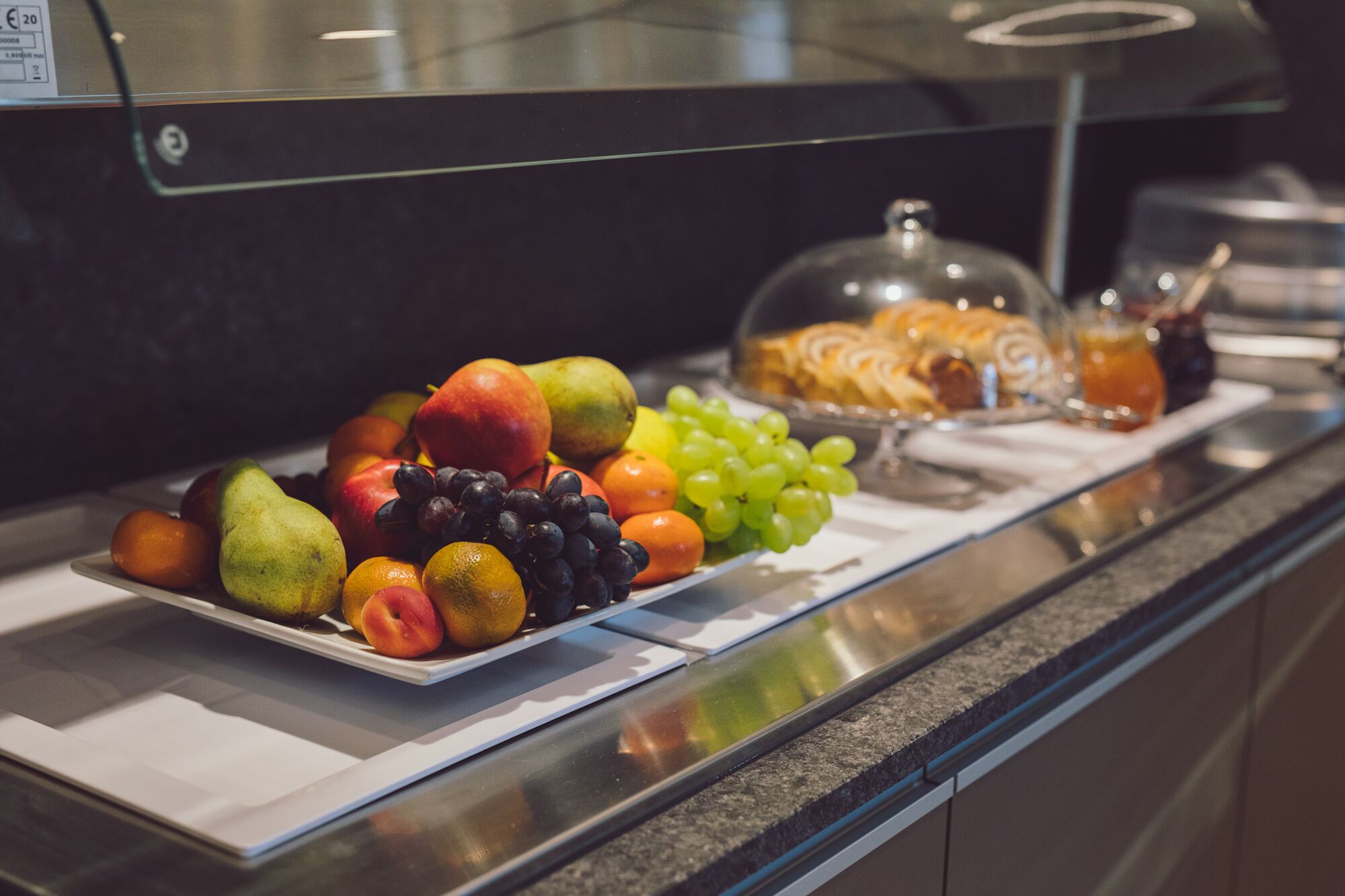 A buffet with various fruits and pastries.