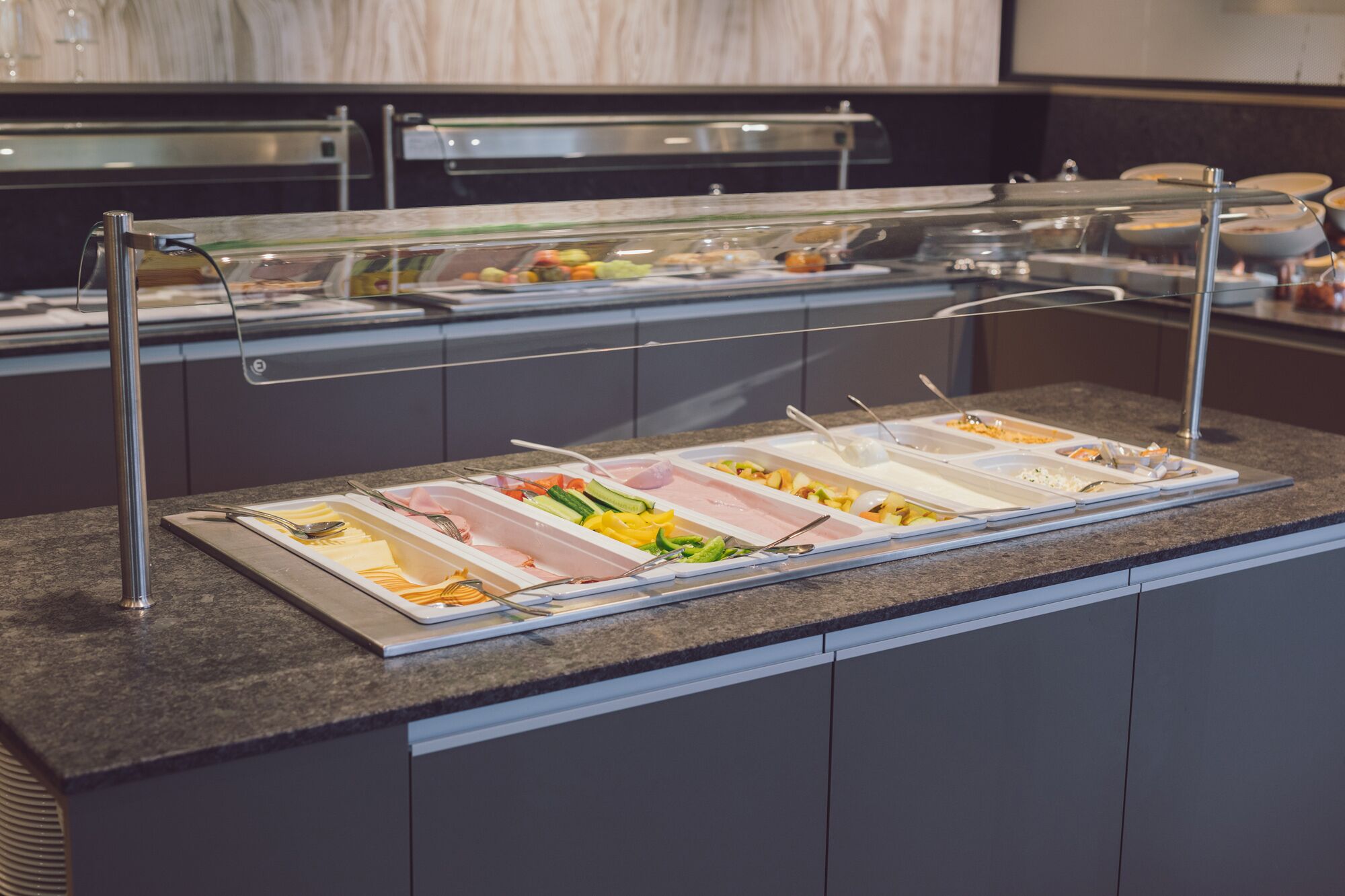 A buffet setup with various food items and utensils.