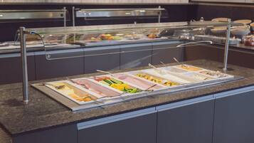A buffet setup with various food items and utensils.