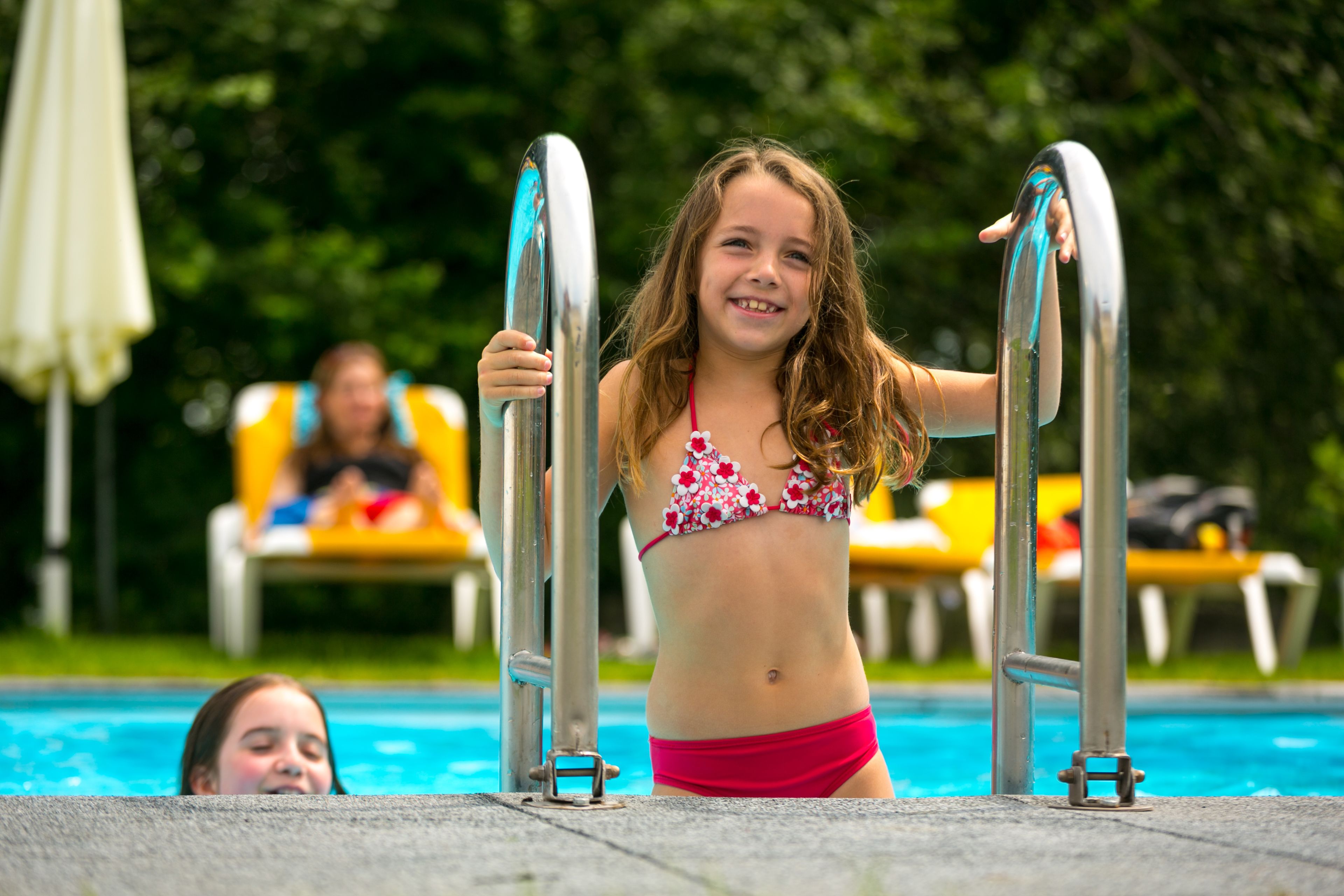 Una piscina al aire libre de temporada, sombrillas
