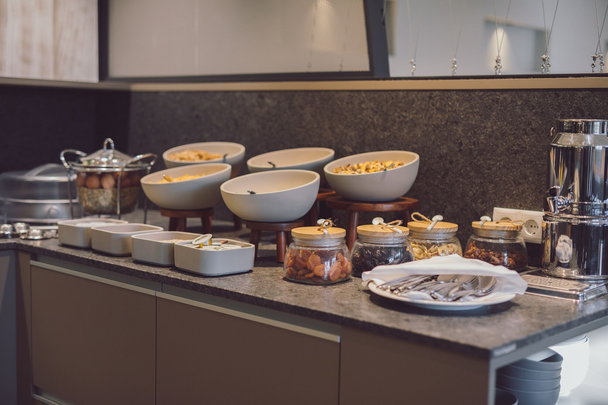 Una encimera de cocina con varios cuencos, tarros y utensilios.