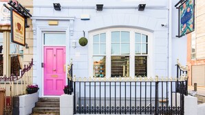 A traditional South Asian restaurant with a pink door, white windows, and a black wrought iron fence. - Jolyon's Boutique Hotel (Cardiff)