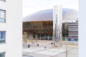 A modern building with a large, curved glass facade and a prominent metallic structure in the foreground. - Jolyon's Boutique Hotel (Cardiff)