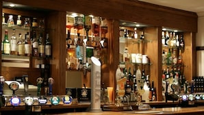 A bar area with multiple beer taps and shelves stocked with various liquor bottles. - The Royal Lodge (Ross-on-Wye)