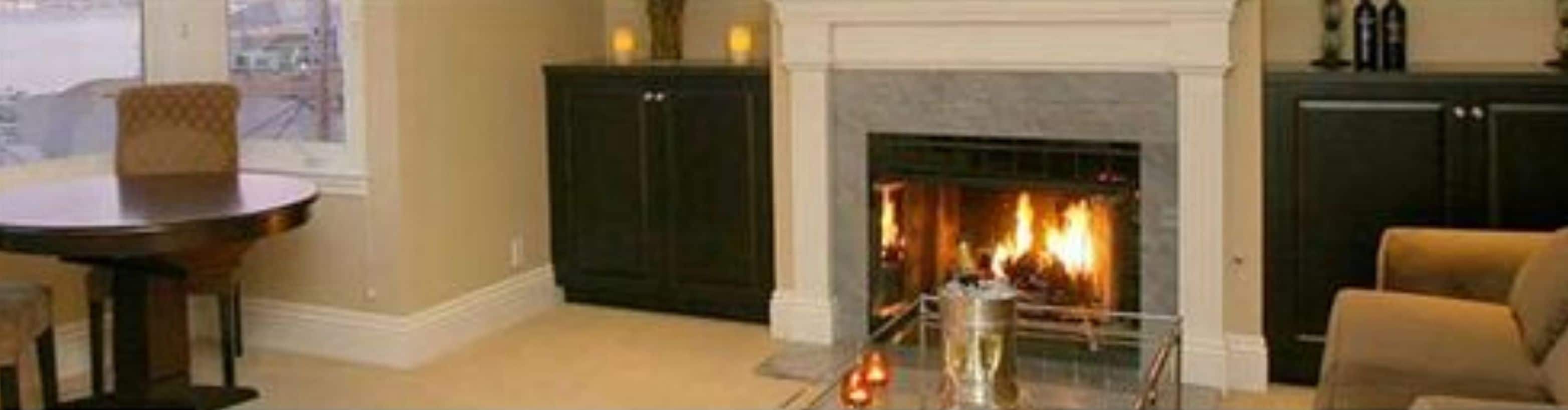 A living room with a fireplace, dark wood cabinets, and a round table.