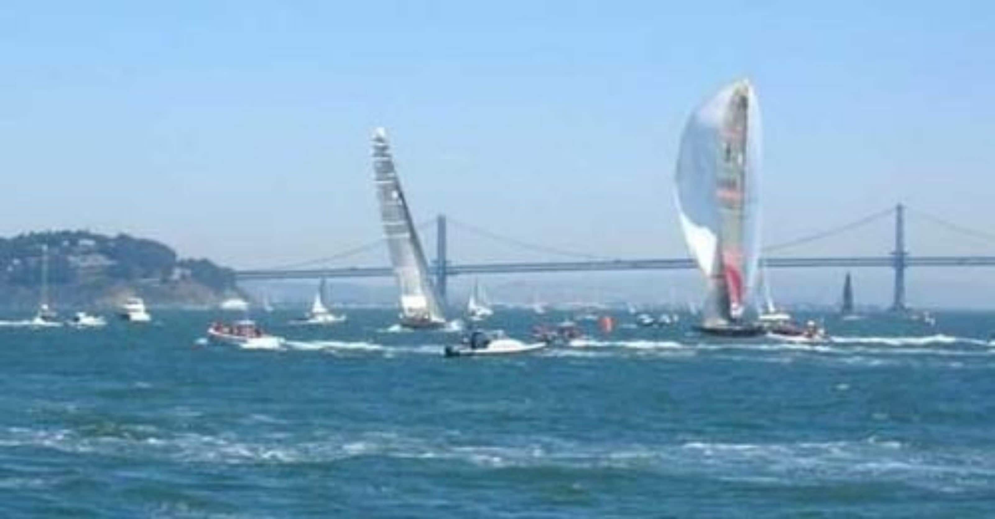 Une vue du pont du Golden Gate avec des voiliers sur l’eau.