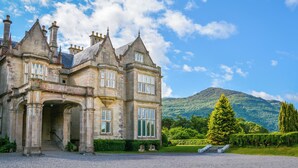 A large, historic stone building with multiple towers and a prominent entrance. - Killarney Heights Hotel (Killarney)