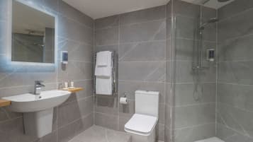 Une salle de bain moderne équipée d’un lavabo, de toilettes et d’une douche.