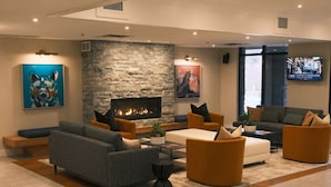 A modern living room with a fireplace, sofas, and a television. - Executive Suites Hotel & Resort, Squamish (Squamish)